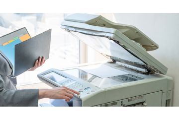 Lavoratrice intenta ad effettuare delle fotocopie